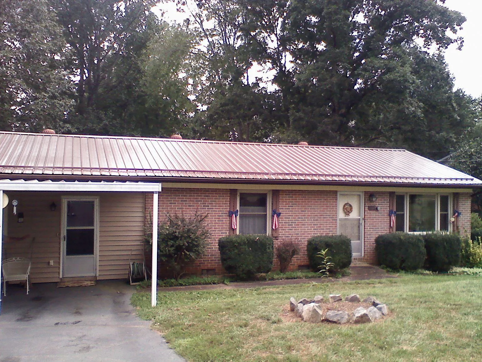 Bronze metal roof and carport on a brick ranch home — Roof Repair work by our crew in Elmwood